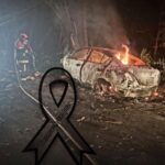 Vehículo queda destruido por un incendio durante la noche: bomberos trabajan para controlar las llamas en una zona rodeada de árboles